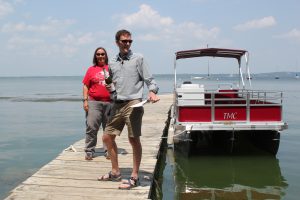 Emily Stanley and Jake Vander Zanden stands on dock beside of new Limnos II pontoon boat