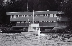 Black and white photo of Hasler Lab with Limnos 1 leaving dock in Lake Mendota