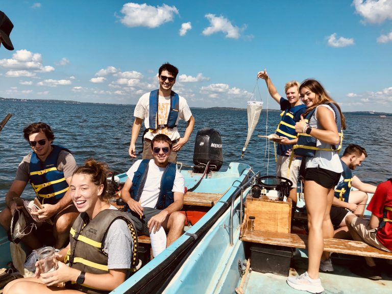 Seven undergraduate students in two Boston Whaler boats sampling water and zooplankton on Lake Mendota.